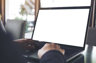 Kafe 'deki boş beyaz ekranla iş kadınının laptopta yazı yazıp kullandığı bir resim.