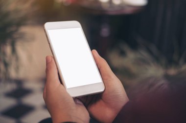 Kafede boş ekranlı beyaz cep telefonlu el kamerası görüntüsü