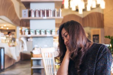 Portre portre resim bir surat, duygu iyi oturan ve modern kafede rahatlatıcı ile güzel Asyalı kadın 