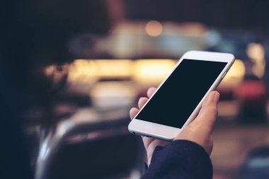 El Beyaz cep telefonu ile boş siyah perde ile tutarak mockup görüntü arka plan bulanıklık
