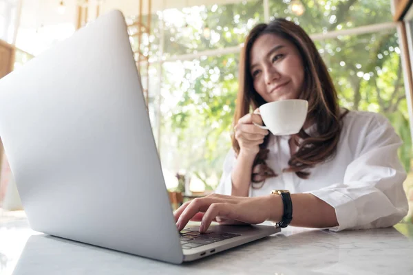 Κοντινή Εικόνα Μιας Όμορφης Ασιάτισσας Που Χρησιμοποιεί Laptop Πίνοντας Καφέ — Φωτογραφία Αρχείου