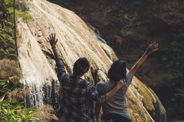 Dos Mujeres Turísticas Levantando Mano Pie Frente Una Hermosa Cascada — Foto de Stock