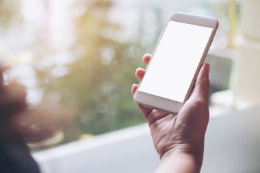 Mockup görüntü tutarak ve gölet ve doğa arka plan ile boş ekran ile beyaz akıllı telefon kullanarak el 