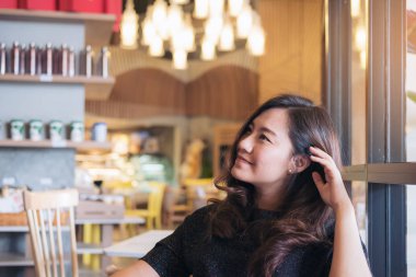 Portre portre resim bir surat, duygu iyi oturan ve modern kafede rahatlatıcı ile güzel Asyalı kadın 