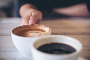 Kodes beyaz kahve bardağı Cafe ahşap masa üzerinde iki kişi görüntü kadar kapatın