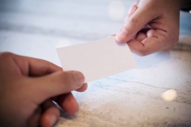 İş kadını ile mermer masa arka plan beyaz boş kartvizit vererek bir iş adamı closeup görüntü