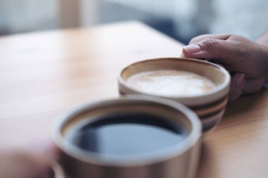 Kodes kahve fincan Cafe ahşap masa üzerinde iki kişi görüntü kadar kapatın
