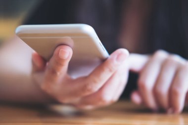 Holding ve modern kafede akıllı telefon kullanarak bir kadın portre resim