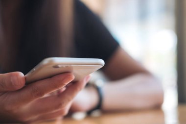 Holding ve modern kafede akıllı telefon kullanarak bir kadın portre resim
