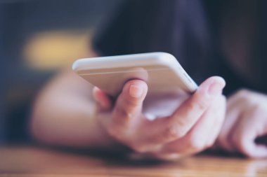Holding ve modern kafede akıllı telefon kullanarak bir kadın portre resim