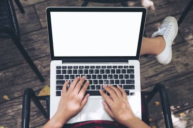 Bir kadın oturmuş, kullanarak ve uyluk, açık arka plan boş beyaz ekran ile dizüstü bilgisayarda yazarak mockup görüntü