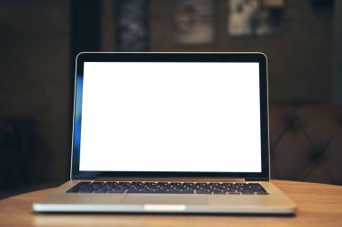 Mockup görüntü karanlık modern Cafe ahşap masa boş beyaz ekran ile dizüstü