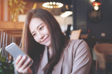 Holding, kullanma ve modern café'akıllı telefon bakarak bir güzel Asya iş kadın portre resim