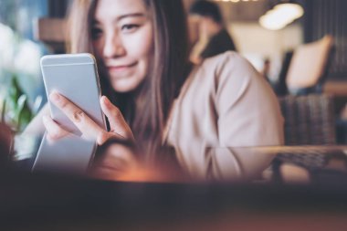 Holding, kullanma ve modern café'akıllı telefon bakarak bir güzel Asya iş kadın portre resim