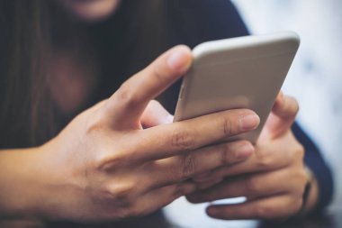 Holding, kullanma ve modern café'akıllı telefon bakarak bir Asyalı closeup görüntü