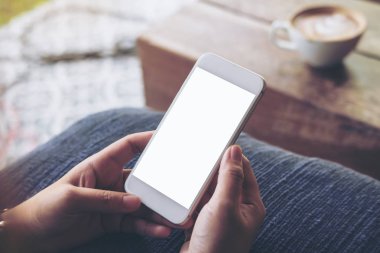 Kadının görüntüsünü mockup holding cep telefonu ile yeşil doğa arka plan ile vintage kafede boş beyaz ekran eller