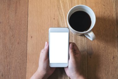 Mockup üstten görünüm görüntüsü ile boş perde ve sıcak kahve Cafe antika ahşap masa üzerinde beyaz cep telefonu