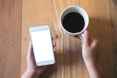 Mockup üstten görünüm görüntüsü ile boş perde ve sıcak kahve Cafe antika ahşap masa üzerinde beyaz cep telefonu