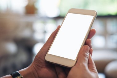 Mockup görüntü tutarak ve istimal hareket eden telefon ile modern kafede boş beyaz ekran ile el bokeh arka plan bulanıklık