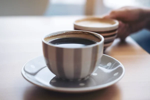 アメリカーノのコーヒーカップと女性の手によるラテコーヒーカップのイメージをカフェでヴィンテージ木製テーブルの上に置きます — ストック写真