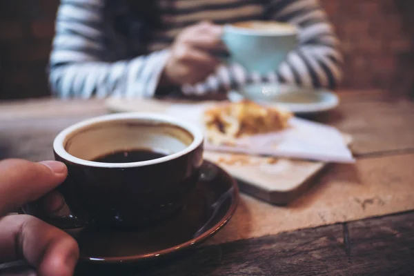 男と押しながらレーズンの一部と一緒にホット コーヒーを飲む女性のクローズ アップ イメージのコーヒー ショップで木のビンテージ テーブルにはデンマーク — ストック写真