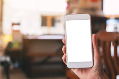 Boş masaüstü ekran ile beyaz cep telefonu tutan bir kadının el görüntüsü 