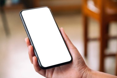 Boş masaüstü ekran ile siyah cep telefonu tutan bir elin görüntüsü 