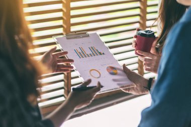 İş adamlarından oluşan bir grup ofiste iş verilerini tartışıyor ve birlikte çalışıyorlar.