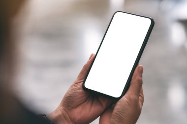 Boş masaüstü ekran ile siyah cep telefonu tutan bir elin görüntüsü 