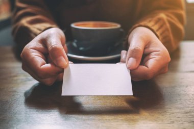 Elinde boş bir kartviziti olan bir kadın.