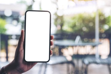 Boş masaüstü ekran ile siyah cep telefonu tutan bir kadının el görüntüsü 