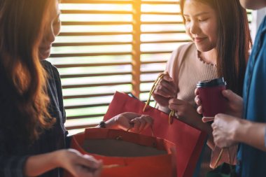 Arkadaşlar birlikte alışveriş çantalarını açıp bakıyorlar.