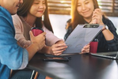 İş adamlarından oluşan bir grup ofiste iş verilerini tartışıyor ve birlikte çalışıyorlar.