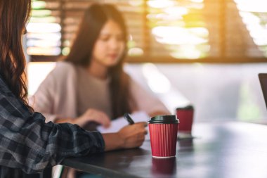 Arka planda iş adamı olan kağıt bir kahve fincanı.
