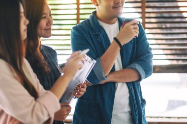 Bir grup iş adamı ofiste beyaz tahtayla fikirleri tartışıyor ve inceliyor.