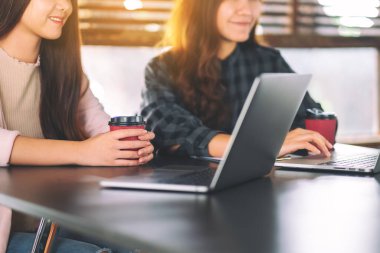 Dizüstü bilgisayarı kullanan ve çalışan kadınlar.