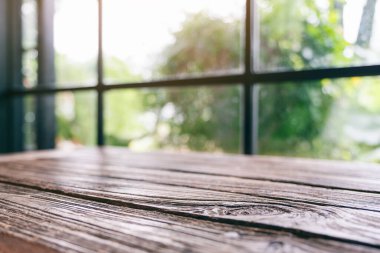 Yeşil arka planı bulanık, eski ahşap bir masanın yakın plan görüntüsü.