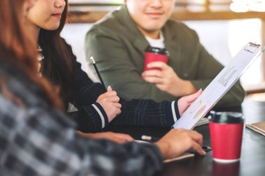 İş adamlarından oluşan bir grup ofiste iş verilerini tartışıyor ve birlikte çalışıyorlar.