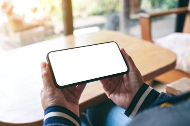 Boş masaüstü ekranı olan siyah cep telefonunu tutan ellerin görüntüsü