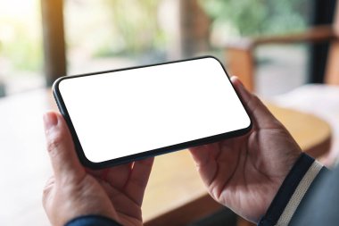 Boş masaüstü ekranı olan siyah cep telefonunu tutan ellerin görüntüsü