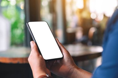 Boş masaüstü ekranı olan siyah cep telefonunu tutan ellerin görüntüsü
