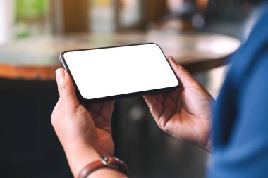 Boş masaüstü ekranı olan siyah cep telefonunu tutan ellerin görüntüsü