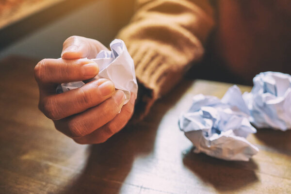 Женщина испачкала бумагу вручную на деревянном столе
 