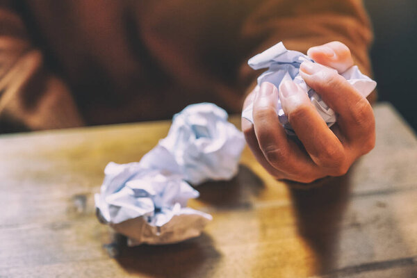 Женщина испачкала бумагу вручную на деревянном столе
 