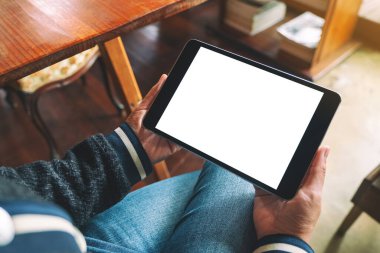 Boş beyaz masaüstü ekran ile siyah tablet bilgisayarını tutan bir kadının görüntüsü 