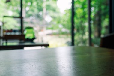 Bulanık yeşil arkaplanı olan ahşap bir masanın yakın plan görüntüsü