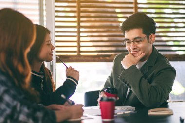 İş adamlarından oluşan bir grup ofiste iş verilerini tartışıyor ve birlikte çalışıyorlar.