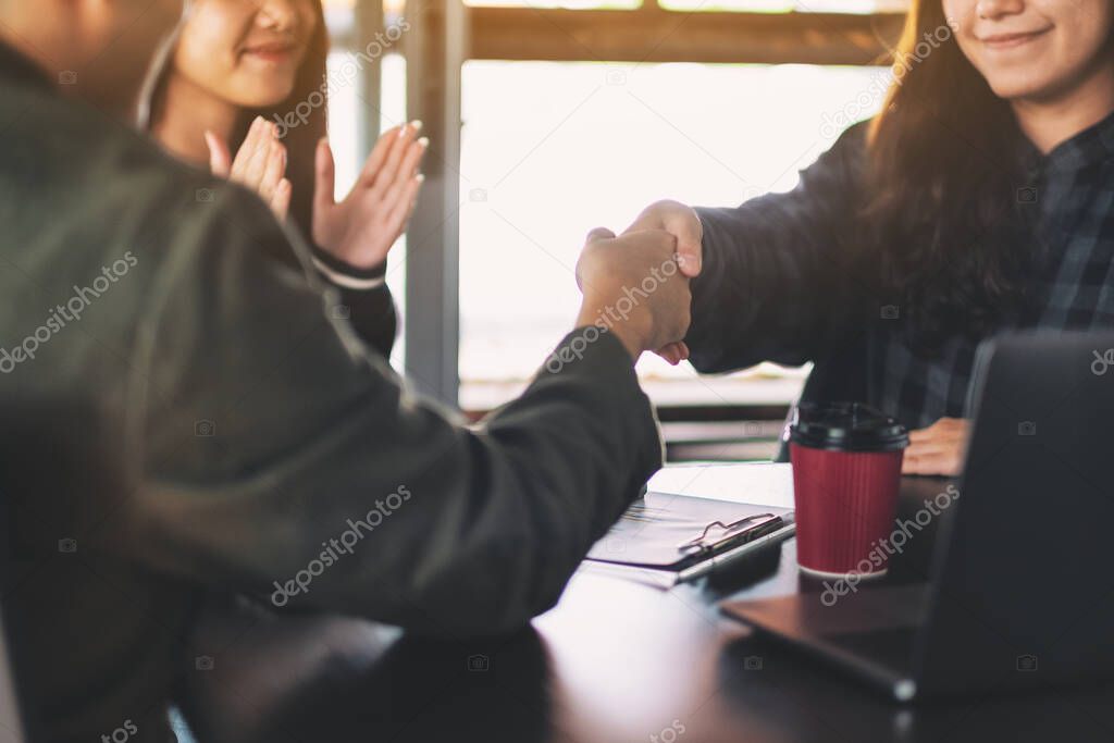 Businesspeople working and shaking hands in a meeting