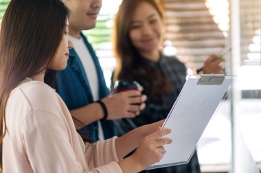 Bir grup iş adamı ofiste beyaz tahtayla fikirleri tartışıyor ve inceliyor.