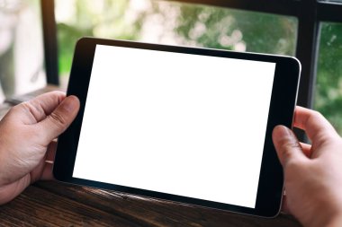 Boş beyaz masaüstü ekranlı siyah tableti tutan ellerin görüntüsü 
